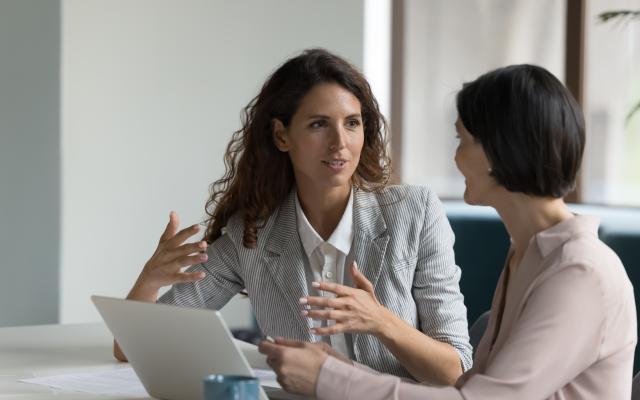 Vrouw doet uitleg aan andere werkneemster 